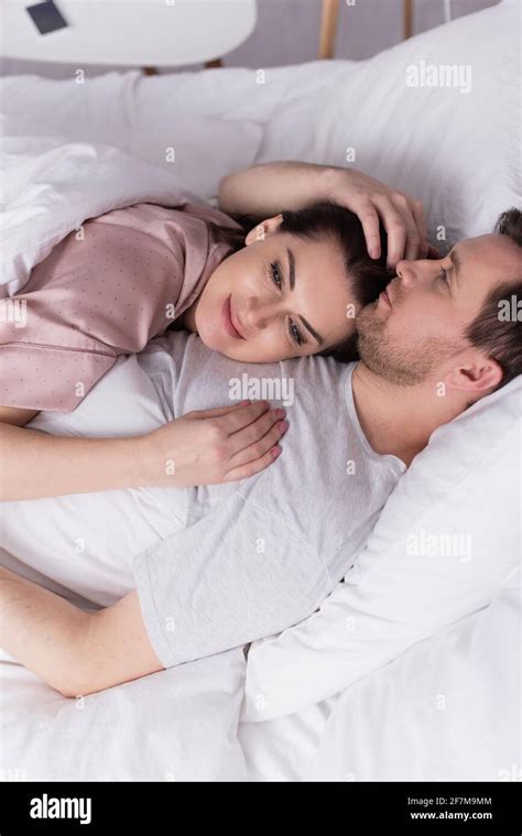 Adult Woman Lying On Chest Of Husband On Bed Stock Photo Alamy