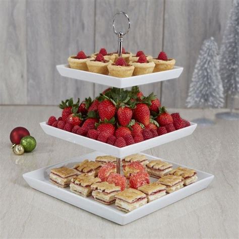 Three Tiered Trays With Strawberries And Mini Pies On Them For Dessert