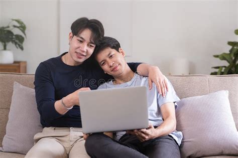 A Gay Couple Spends Their Free Time Sitting On A Laptop Doing Activities Together On A Holiday