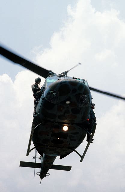 A View Of An Uh 1n Iroquois Helicopter Landing As Crew Members Stand