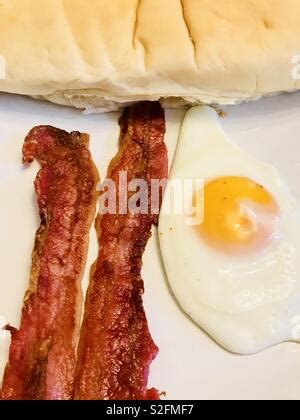 A Fried Egg And Two Rashers Of Streaky Bacon With Tomato Ketchup On A