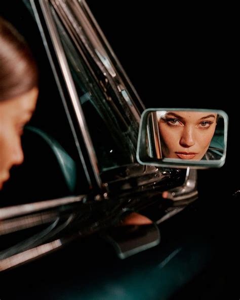 A Woman Looking At Her Reflection In The Side Mirror Of A Car