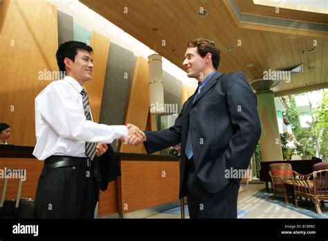 businessmen from different cultures handshaking at hotel reception Stock Photo - Alamy