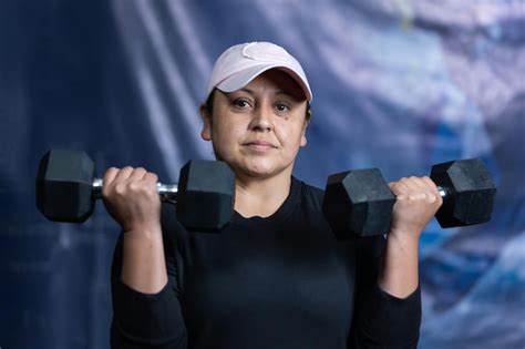 Premium Photo Middleaged Latina Woman Exercising With Two Dumbbells