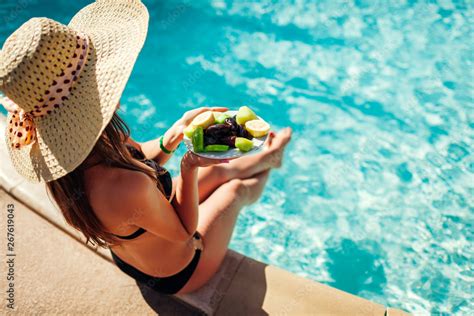 Woman In Bikini Eating Fruits And Relaxing In Swimming Pool All Inclusive Summer Vacation