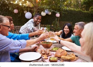 Group Mature Friends Enjoying Outdoor Meal Stock Photo