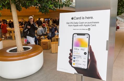 Hand holding an iPhone showing on its display a list of transactions ...