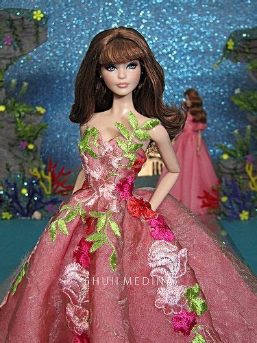 A Barbie Doll Wearing A Pink Dress With Flowers On It S Chest And Shoulder