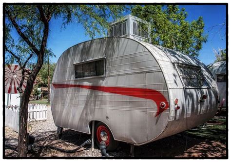 An Old Trailer Is Parked In The Shade