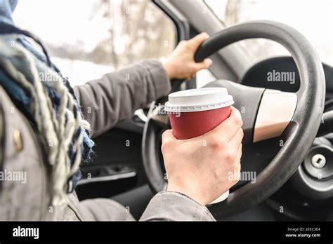 Driver Drinking Coffee In The Car Driving And Holding A Steering Wheel