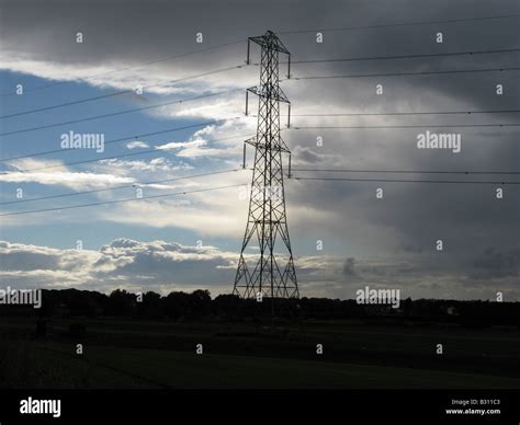 Electricity Pylon With Storm Clouds And Blue Sky Background Stock Photo