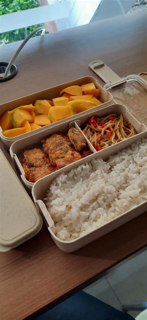 Two Trays Filled With Food Sitting On Top Of A Wooden Table