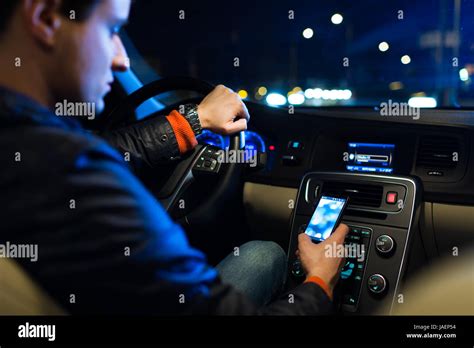 Driving a car at night -man driving his modern car at night in a city ...