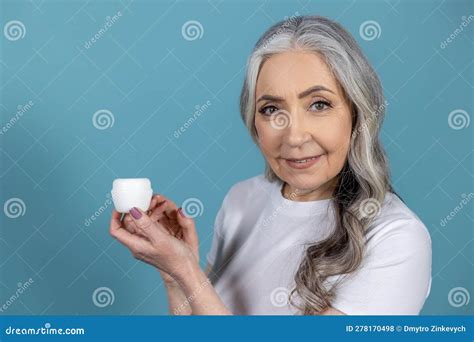 Long Haired Senior Good Looking Woman Holding A Jar Of Face Cream Stock