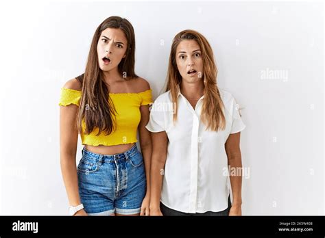 Mother And Daughter Together Standing Together Over Isolated Background In Shock Face Looking