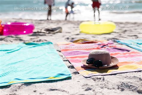 Sunglasses With Hat Placed On Towels Over Sandy Beach During Sunny Day Copy Space Unaltered