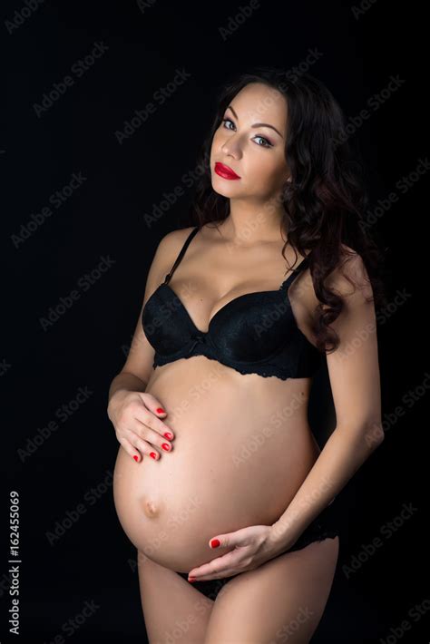 Portrait Of A Beautiful Pregnant Woman In Black Lingerie Studio On A Black Background Stock