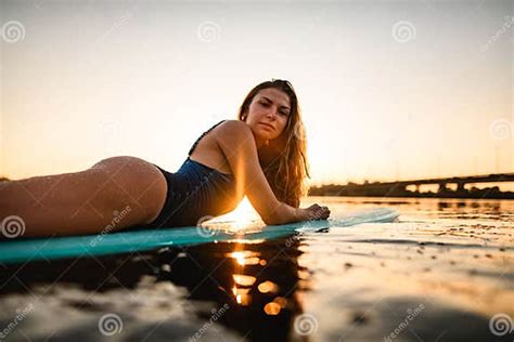 Side View Of Attractive Woman With Long Hair Lying On Surf Style