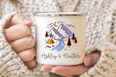 A Person Holding A Coffee Mug With A Camping Scene On It