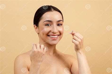 Young Indian Woman Using Dental Floss For Cleaning Her Teeth Stock