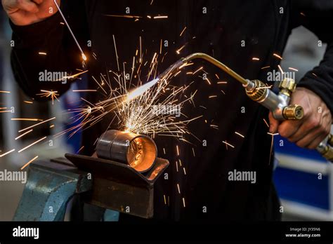 Welding, with a welding torch two metal pipes are welded, training ...