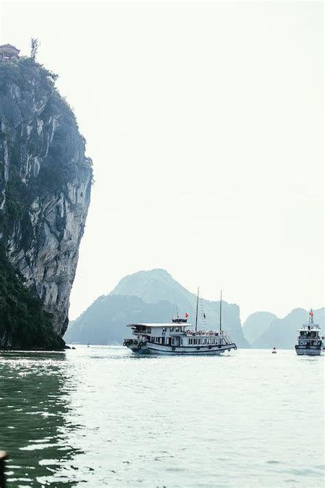 Boats Sailing On Body Of Water Near Rock Mountain · Free Stock Photo