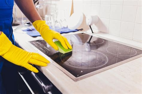 Premium Photo | Cleaning kitchen hob with a steam cleaner