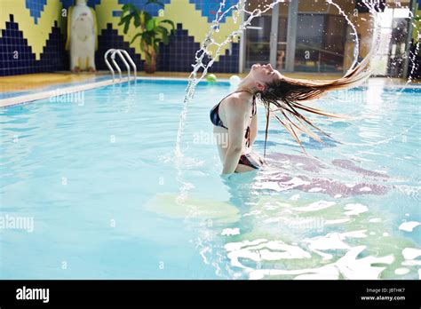 Portrait Of A Gorgeous Firl In Bikini Making A Splash With Her Hair In The Pool In Water Park