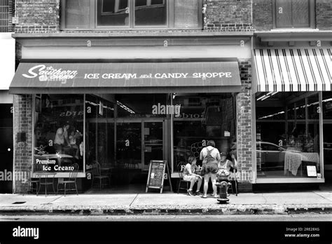 Customer Relax At Outdoor Tables In Front Of An Ice Cream Shop In