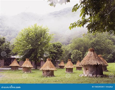 Wooden Beehives With Thatched Roof And Mountains In The Clouds Stock