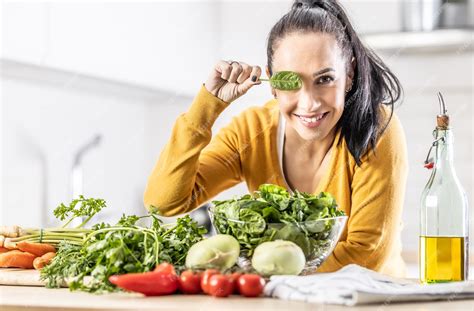 Premium Photo Nice Young Woman Holding A Spinach Leaf Covering Her