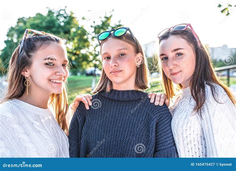 Три школьницы-подростки в возрасте 13-15 лет, позируют для фотографии ...