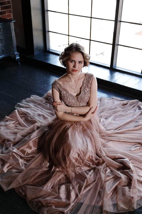 The Girl The Brunette In A Beautiful Dress Poses Sitting On A Floor Stock Photo Image Of