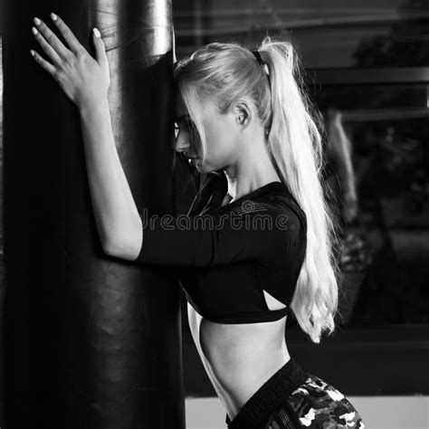 Blonde Woman Posing With Boxing Gloves And Punching Bag Stock Image