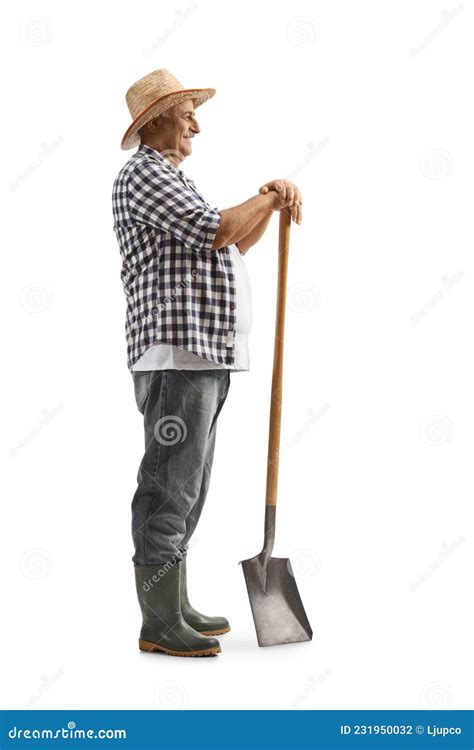 Full Length Profile Shot Of A Mature Farmer Standing With A Shovel