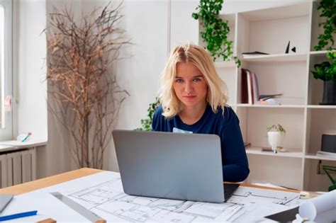 Premium AI Image A Blonde Woman With Medium Length Straight Hair Sits At A Desk With A Laptop
