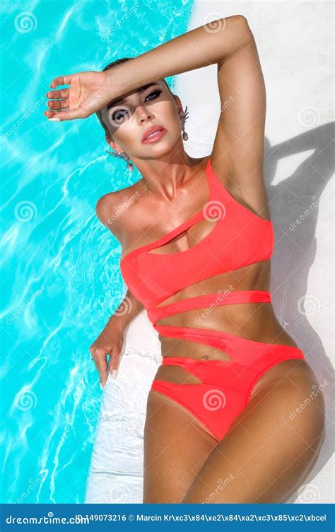 Elegant Woman In The Orange Bikini On The Sun Tanned Slim And Shapely