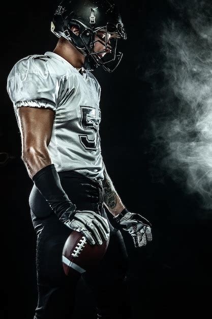 Premium Photo American Football Sportsman Player In Helmet On Black