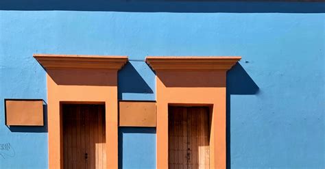 Doors In Blue Building Wall · Free Stock Photo