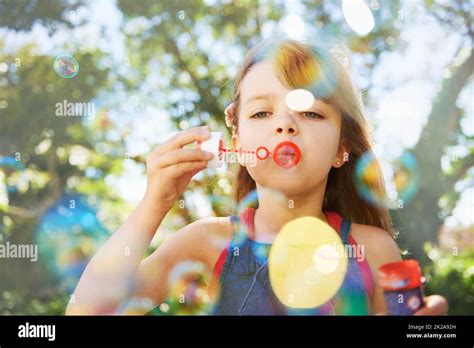 Bubbles And Summer Vacation Shot Of A Cute Young Girl Blowing Bubbles