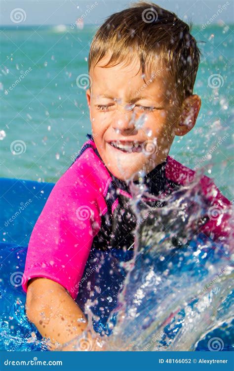 Muchacho Feliz Que Disfruta De Nadar En El Mar Con Caucho Foto De