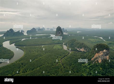 Expanse of lush vegetation, tranquil waterways and rock formations under a cloudy sky at air