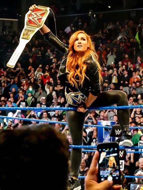 two women and one man are holding up the wwe championship belts in front of them