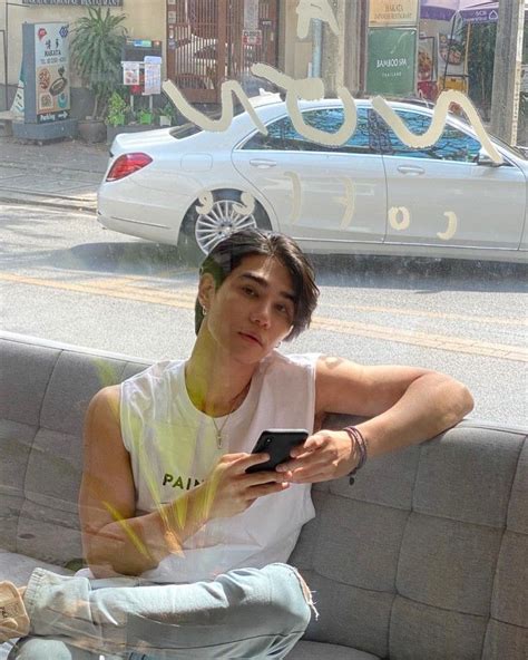 A Woman Sitting On A Couch Looking At Her Cell Phone In Front Of A Car