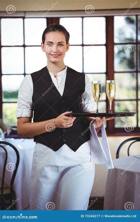 Portrait Of Waitress Holding Serving Tray With Champagne FlutesÂ Stock