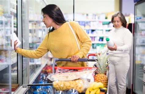 Latina Choosing Dairy Products In Fridge At Grocery Store Stock Image
