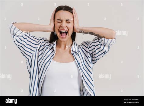 Irritated Beautiful Brunette Girl Screaming And Covering Her Ears Isolated Over White Background