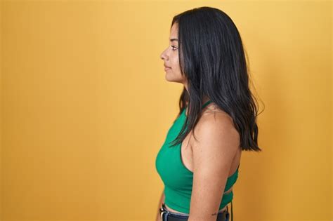 Brunette Femme Debout Sur Fond Jaune à La Recherche De Côté Relax Pose De Profil Avec Un Visage