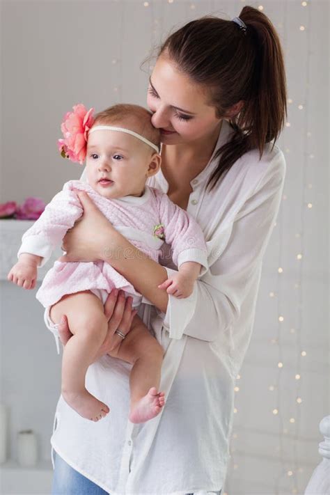 Happy Mother Holding Her Baby Girl In Studio Stock Photo Image Of