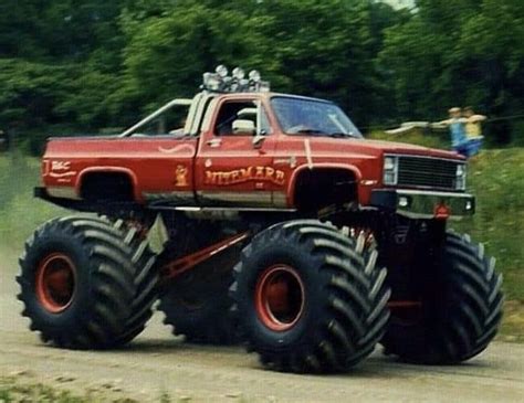 Red Monster Truck Driving Down A Dirt Road